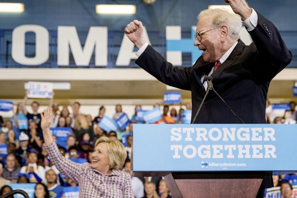 Berkshire Hathaway Chairman and CEO Warren Buffett cheers as he and Democratic presidential candidate Hillary Clinton arrive at a rally at Omaha North High Magnet School in Omaha, Neb., Monday, Aug. 1 ...