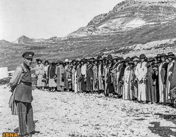 Der iranische König Resa Pahlawi in den 1930er-Jahren vor einer Gruppe nomadischer Frauen, die ihre Schleier gegen europäische Kleidung austauschen mussten.