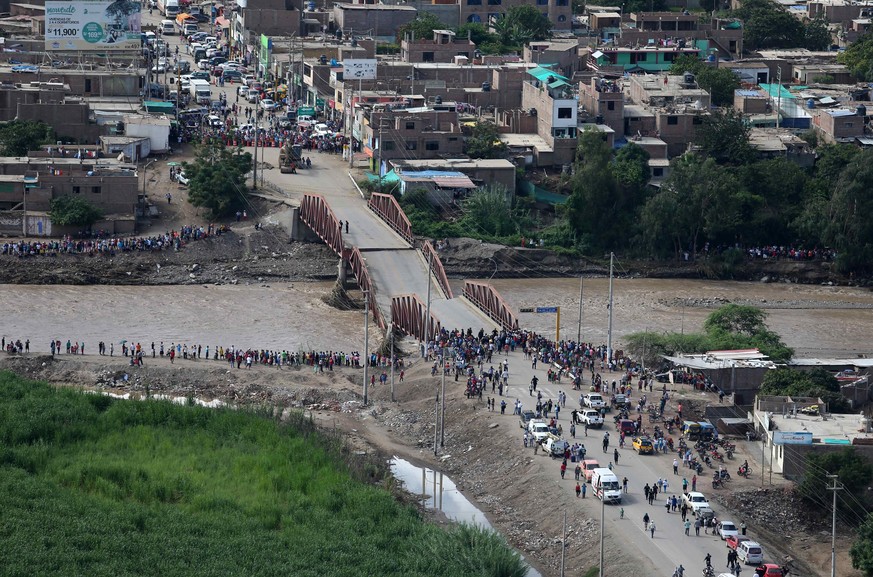 epa05858633 Aerial photograph shows a group of stranded inhabitants due to the flooding of the Viru River, which destroyed several bridges connecting various villages in the northern region of La Libe ...