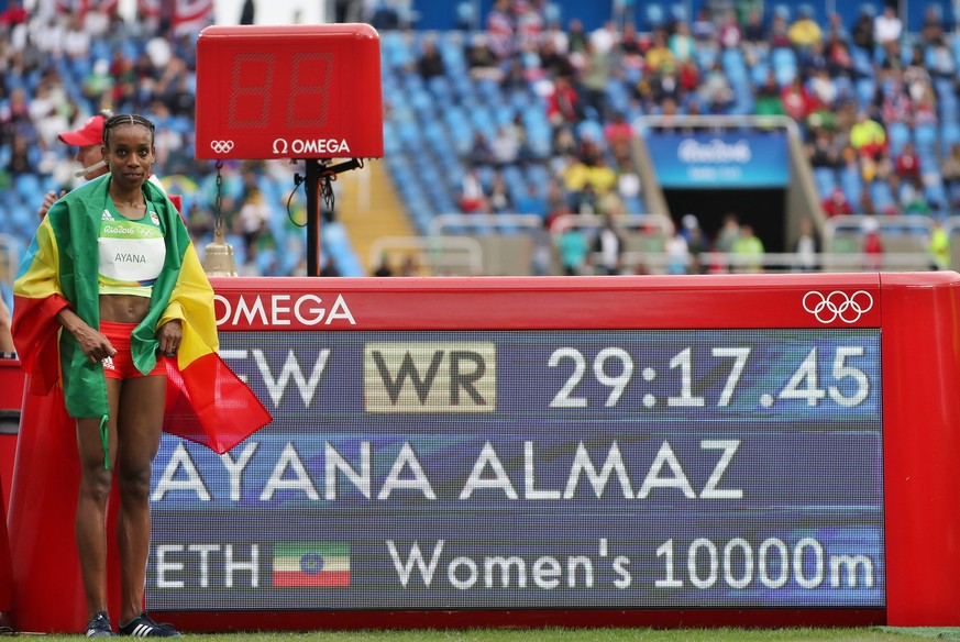 epa05477024 Almaz Ayana of Ethiopia poses in front of the scoreboard after winning the women&#039;s 10000m final with a new world record at the Rio 2016 Olympic Games Athletics, Track and Field events ...