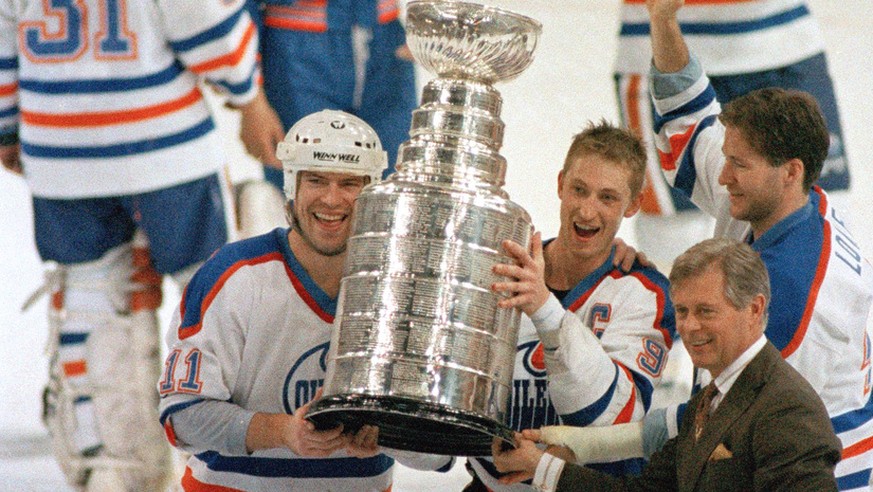 Edmonton Oilers team captain Wayne Gretzky, right, and Mark Messier hold up the Stanley Cup trophy following the team&#039;s 6-3 win over the Boston Bruins in the Stanley Cup hockey finals in Edmonton ...