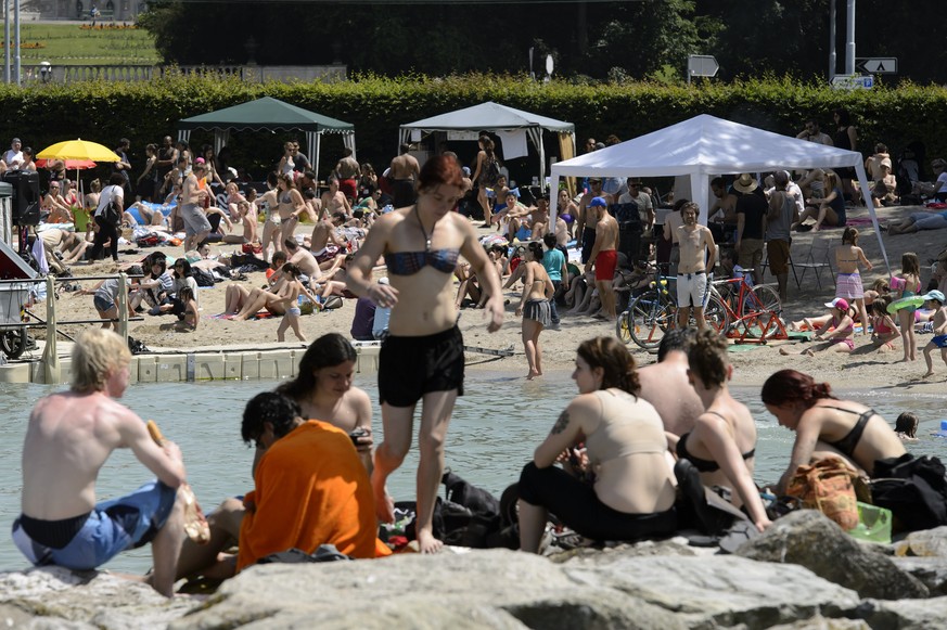 Badegäste am Genfersee geniessen die Sonne.