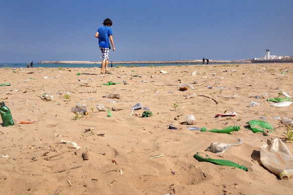 Der Niederländer wandert durch Plastikmüll an einem Strand in Marrokko.