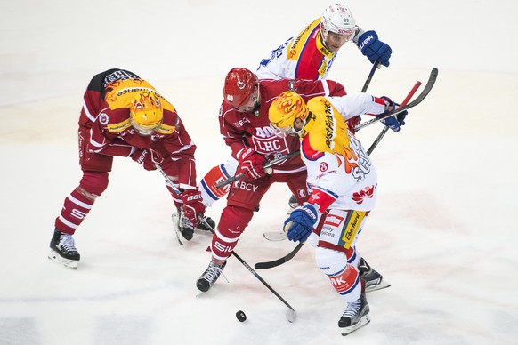 Le Topscorer lausannois Jonas Junland, gauche, et l&#039;attaquant lausannois Etienne Froidevaux, 2eme gauche, luttent pour le puck avec l&#039;attaquant de Kloten Tommi Santala, 2eme droite, et le To ...