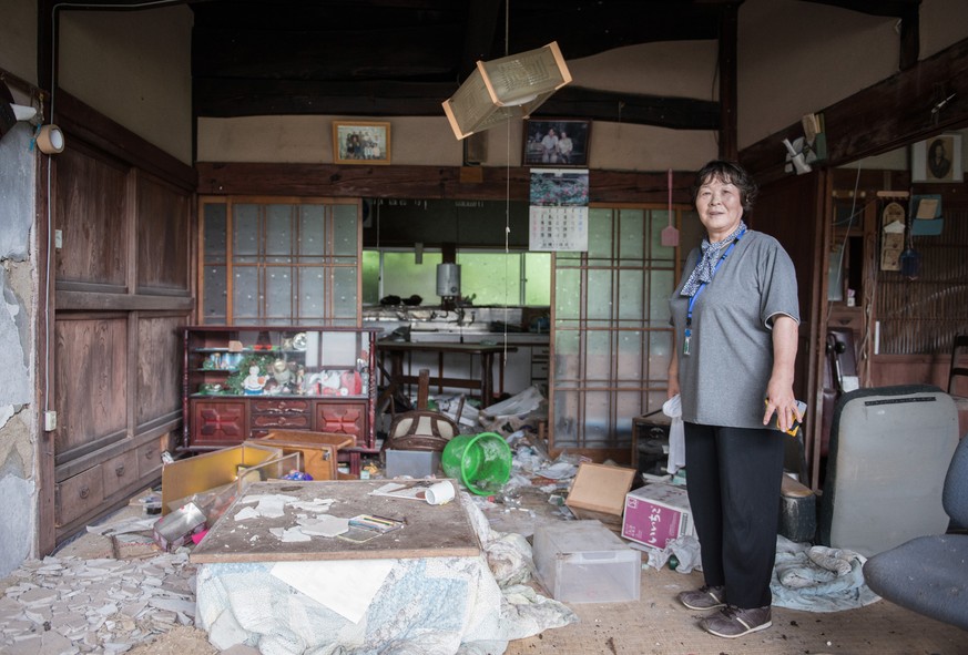 Yukiko Tajiri in dem Haus, wo sie vor der Evakuierung gelebt hat.&nbsp;Das Erdbeben hat den Häusern nur marginalen Schaden zugefügt, und aufgrund ihrer Entfernung vom Ozean waren sie auch keiner Gefah ...