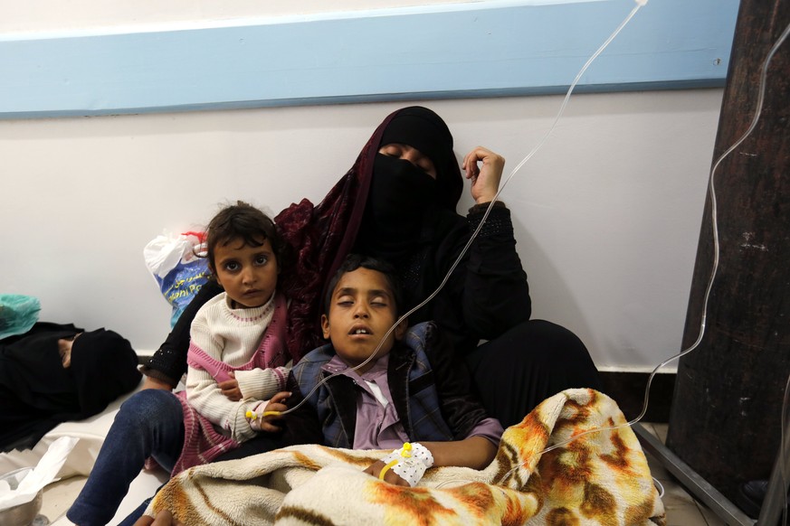 epa05950851 A Yemeni woman holds her cholera-infected children as they receive treatment at a hospital in Sanaa, Yemen, 08 May 2017. According to the World Health Organization, a total of 25 Yemenis  ...