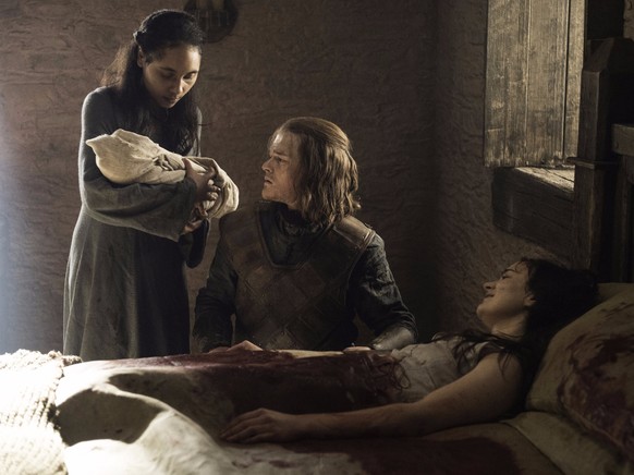 Dem jungen Königssohn Ned Stark wird von einer Amme das Kind gezeigt, das seine Schwester (sterbend im Bett) zur Welt gebracht hat.