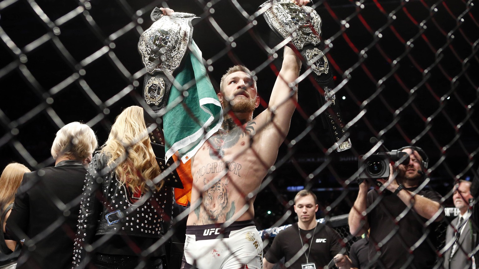 Nov 12, 2016; New York, NY, USA; Conor McGregor (blue gloves) celebrates with his two championship belts after defeating Eddie Alvarez (red gloves) in their lightweight title bout during UFC 205 at Ma ...