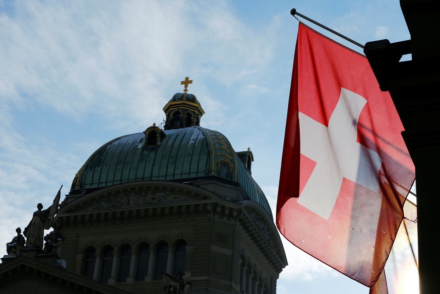 A Swiss flag is pictured in front of the Federal Palace (Bundeshaus) is pictured in Bern, Switzerland, January 16, 2017. Picture taken on January 16, 2017. REUTERS/Denis Balibouse