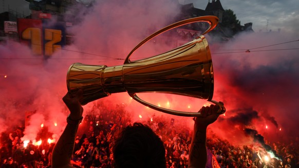 Ein Spieler des FC Basel stemmt an der offiziellen Meisterfeier des Clubs am Samstag, 3. Juni 2017 den Meisterpokalauf dem Balkon am Barfuesserplatz in Basel in die Hoehe. (KEYSTONE/POOL FCB/Uwe Zinke ...