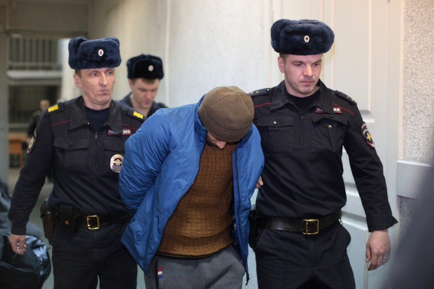 Guards escort a suspect into a court hearing in St. Petersburg, Russia, Thursday, April 6, 2017. Police in St. Petersburg have arrested several people as part of a probe into the subway bombing earlie ...