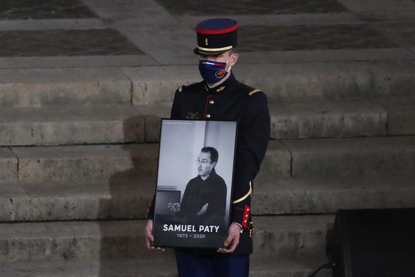 Nachrichten Linkding FILE - A Republican Guard holds a portrait of Samuel Paty in the courtyard of the Sorbonne university during a national memorial event, Wednesday, Oct. 21, 2020 in Paris. (AP Photo/Francois Mori, Pool ...