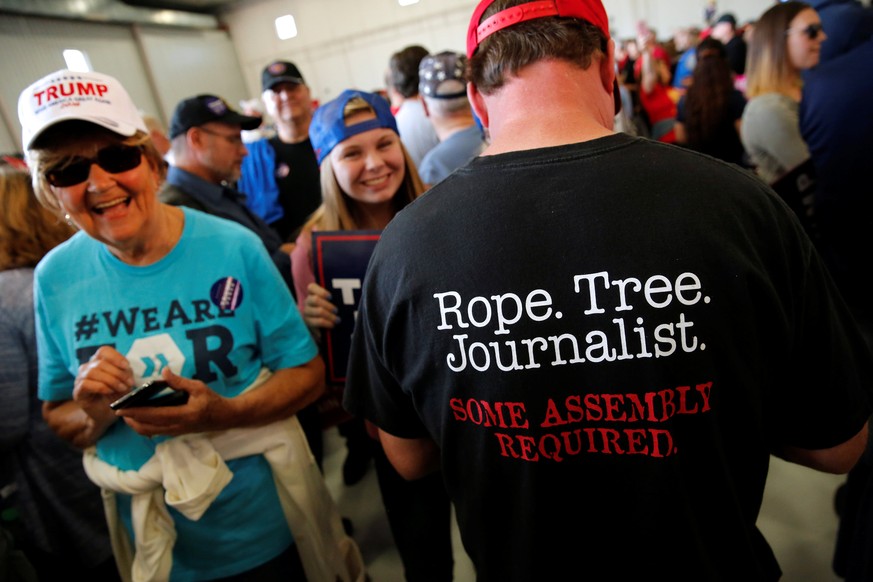 A man wears a shirt reading &quot;Rope. Tree. Journalist.&quot; as supporters gather to rally with Republican presidential nominee Donald Trump in a cargo hangar at Minneapolis Saint Paul Internationa ...