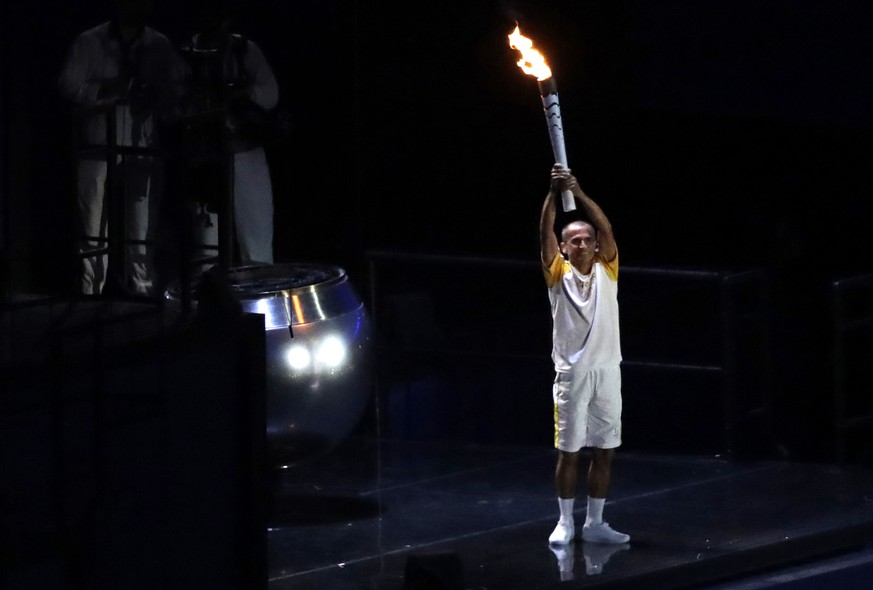 Brazilian former long-distance runner Vanderlei de Lima holds the Olympic flame during the opening ceremony of the 2016 Summer Olympics in Rio de Janeiro, Brazil, Saturday, Aug. 6, 2016. (AP Photo/Rob ...