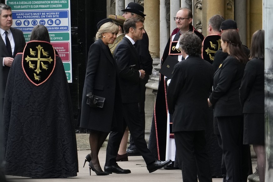 French President Emmanuel Macron and his wife Brigitte enter Westminster Abbey before the coffin of Queen Elizabeth II is carried inside for her funeral in central London, Monday, Sept. 19, 2022. The  ...