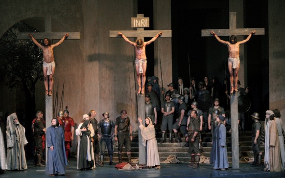 ARCHIV - Der Darsteller Frederik Mayet als Jesus (M) hängt am 10.05.2010 in Oberammergau (Oberbayern) in der Fotoprobe zu den Oberammergauer Passionsspielen in der Kreuzigungs-Szene am Kreuz, während  ...