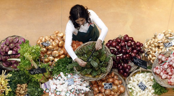 An employee arranges pricetags at a vegetables work bench during the opening day of upmarket Italian food hall chain Eataly&#039;s flagship store in downtown Milan, March 18, 2014. Eataly, which began ...