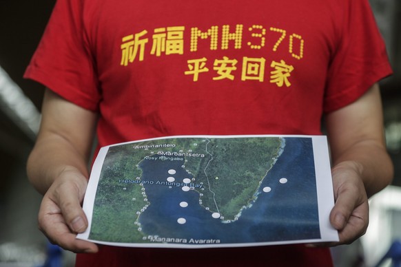 epa05657543 MH370 next-of-kin Jiang Hui from China holds a map during a press conference at Kuala Lumpur International Airport in Sepang, Malaysia, 03 December 2016, before their trip to Madagascar. F ...