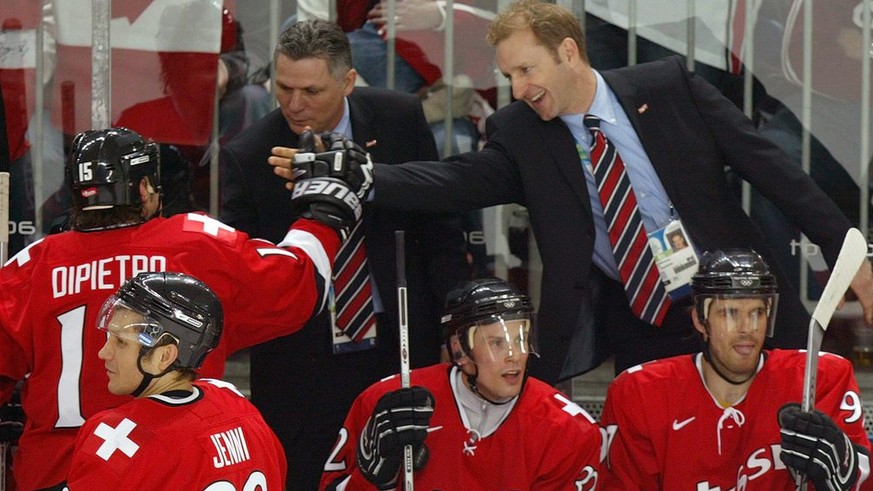 Swiss head coach, Canadian-German Ralph Krueger, right, congratulates his forward Paul di Pietro, left, who just scored his first of two goals, next to assistant coach Canadian Peter John Lee, center, ...