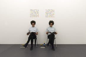 Zwillinge sitzen vor Damien Hirsts Zwillingsbildern.