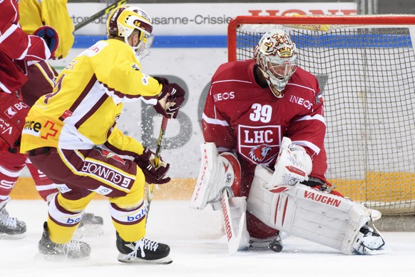 Le defenseur genevois Juraj Simek, gauche, lutte pour le puck avec le gardien lausannois Cristobal Huet, droite, lors du match du championnat suisse de hockey sur glace de National League LNA, entre l ...