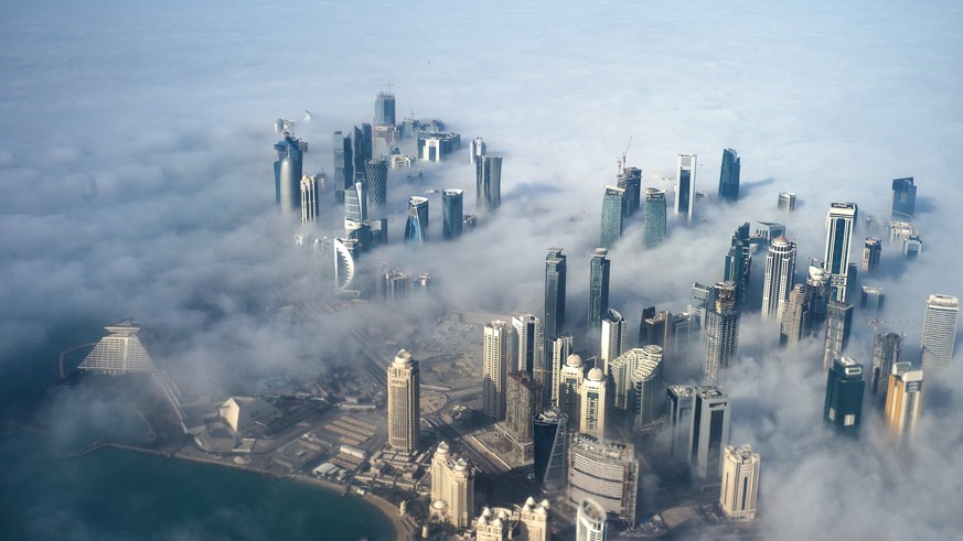 epa06052579 (FILE) - An aerial view of high-rise buildings emerging through fog covering the skyline of Doha, as the sun rises over the city, in Doha, Qatar, 15 February 2014 (reissued 27 June 2017).  ...