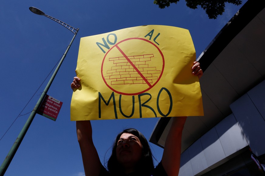 A woman holds a placard that reads &quot;No to the wall&quot;, during a protest against U.S. President Donald Trump outside a Ford dealership in Mexico City, Mexico January 20, 2017. REUTERS/Carlos Ja ...