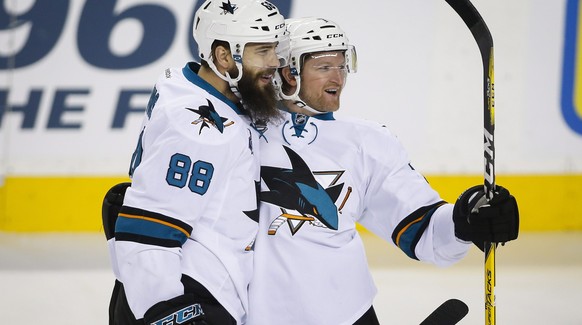 San Jose Sharks&#039; Brent Burns, left, celebrates his goal with teammate Paul Martin during first period NHL hockey action against the Calgary Flames in Calgary, Monday, March 7, 2016. (Jeff McIntos ...