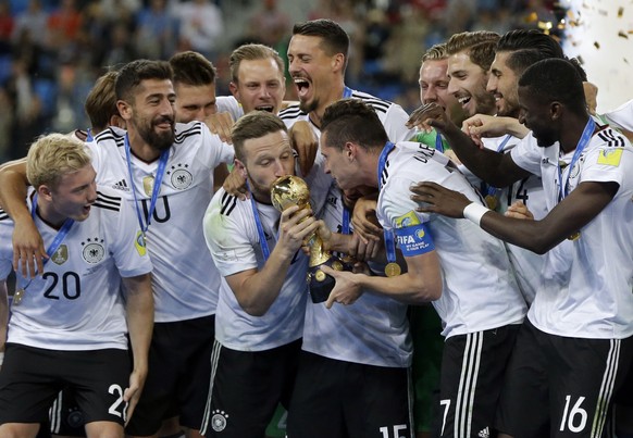 Germany&#039;s Shkodran Mustafi kisses the trophy held by Julian Draxler after winning the Confederations Cup final soccer match between Chile and Germany, at the St.Petersburg Stadium, Russia, Sunday ...