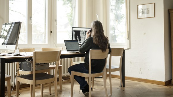 Eine Frau telefoniert an ihrem Arbeitsplatz im Homeoffice. Mit dem Homeoffice ergeben sich besondere Herausforderungen f