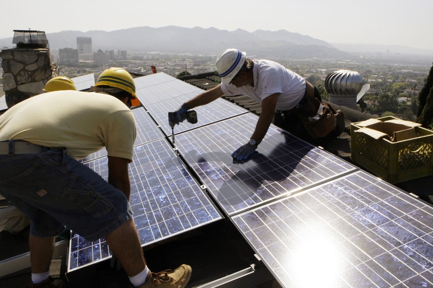 FILE - In this March 23, 2010, file photo, installers from California Green Design install solar electrical panels on the roof of a home in Glendale, Calif. The Obama administration is boosting the de ...