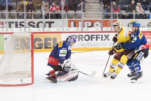 Servettes Stuermer Cody Almond, Mitte, erzielt ein Tor (1-0) gegen Biel Torhueter Jonas Hiller, links, und Biel Spieler Benoit Jecker, rechts, beim Eishockey Meisterschaftsspiel der National League A  ...