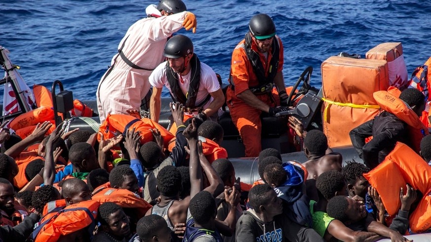 Medecins Sans Frontieres (MSF) field coordinator, Michele Telaro, together with two members of the Bourbon Argos crew, distribute lifejackets during a rescue operation in the Mediterranean Sea, Wednes ...