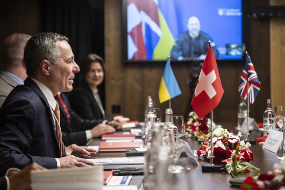 epa10413913 Swiss Federal Councillor Ignazio Cassis (L) hosts a multilateral meeting on the reconstruction of Ukraine, with Ukrainian Prime Minister Denys Shmyhal (on screen) linked over video confere ...