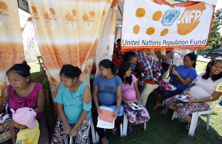 Pregnant women who survived Typhoon Haiyan wait for their pre-natal examination outside a makeshift clinic of the United Nations Population Fund (UNFPA) in Tacloban city in central Philippines Novembe ...