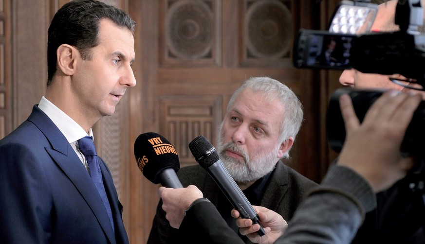 epa05775847 A handout photo made available by the official Syrian Arab News Agency (SANA) on 07 February 2017 shows Syrian President Bashar al-Assad (L) speaking to Belgian media in Damascus, Syria, 0 ...