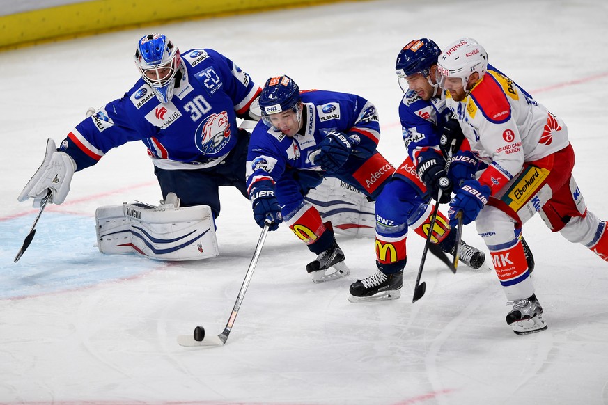 Die Zuercher Lukas Flueeler, Patrick Geering, David Rundblad, von links, gegen den Klotener Matthias Bieber beim Eishockey-Meisterschaftsspiel der National League A zwischen den ZSC Lions und dem EHC  ...