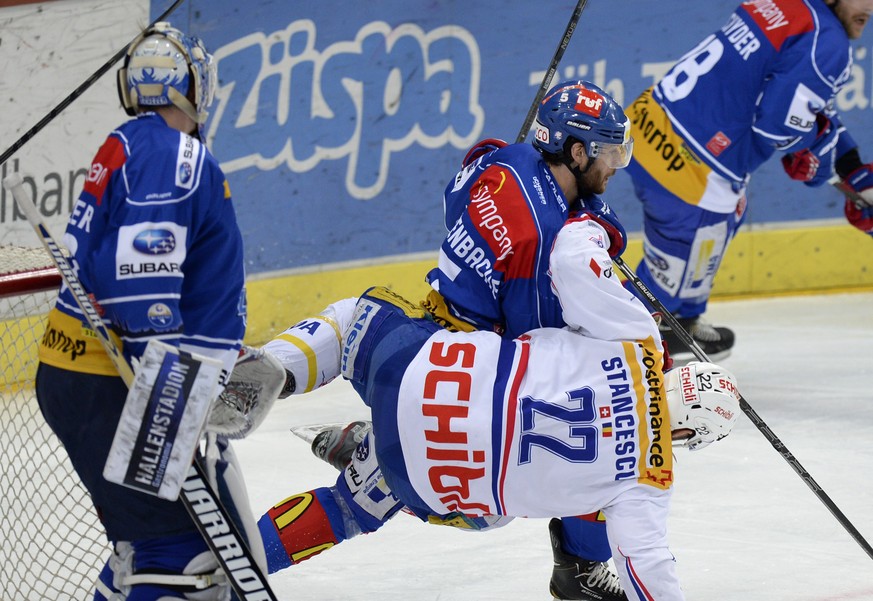 Der Zuercher Severin Blindenbacher, hinten, und der Klotener Victor Stancescu, vorne, im ersten Playoff Finalspiel der National League A zwischen den ZSC Lions und den Kloten Flyers, am Samstag, 12. A ...