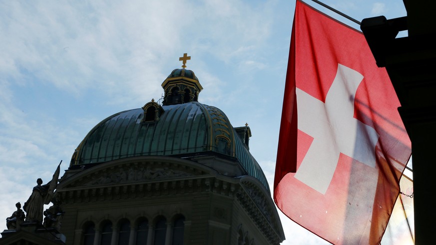 A Swiss flag is pictured in front of the Federal Palace (Bundeshaus) is pictured in Bern, Switzerland, January 16, 2017. Picture taken on January 16, 2017. REUTERS/Denis Balibouse