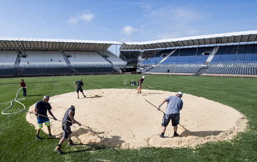 Des ouvriers apportent la sciure au milieu de l&#039;arene sur le site de la Fete federale de lutte et des jeux alpestres (Eidgenoessisches Schwing- und Aelplerfest), Estavayer 2016, ce vendredi 19 ao ...