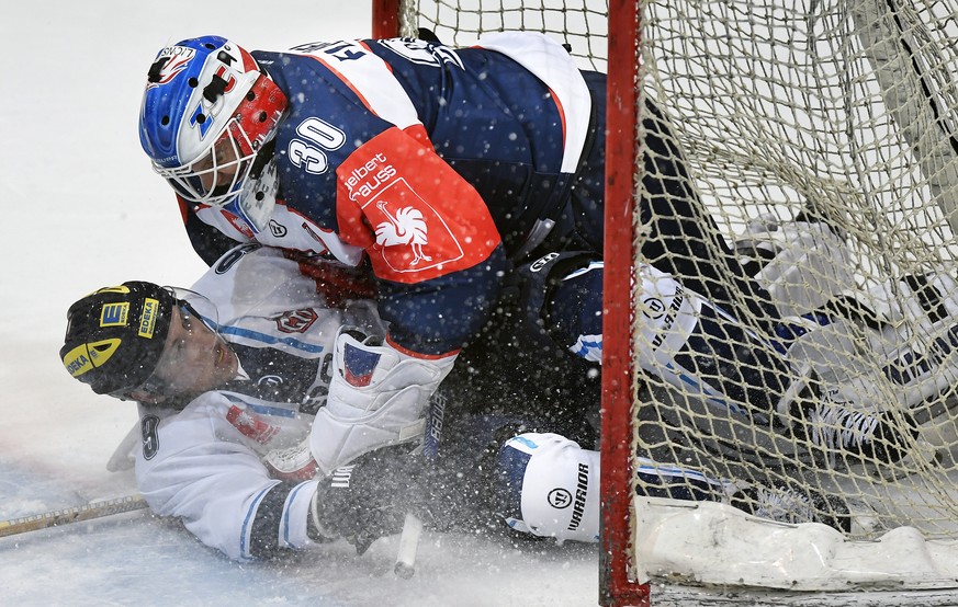 Zurich&#039;s goalkeeper Lukas Flueeler, right, fights with Ingolstadt&#039;s Brandon Buck, left, during the Champions Hockey League Group D hockey match between Switzerland&#039;s ZSC Lions and Germa ...