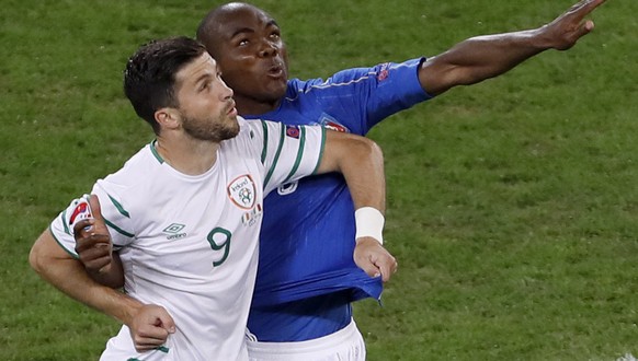 Italy&#039;s Angelo Ogbonna jumps for the ball next to Northern Ireland&#039;s Will Grigg during the Euro 2016 Group E soccer match between Italy and Ireland at the Pierre Mauroy stadium in Villeneuve ...