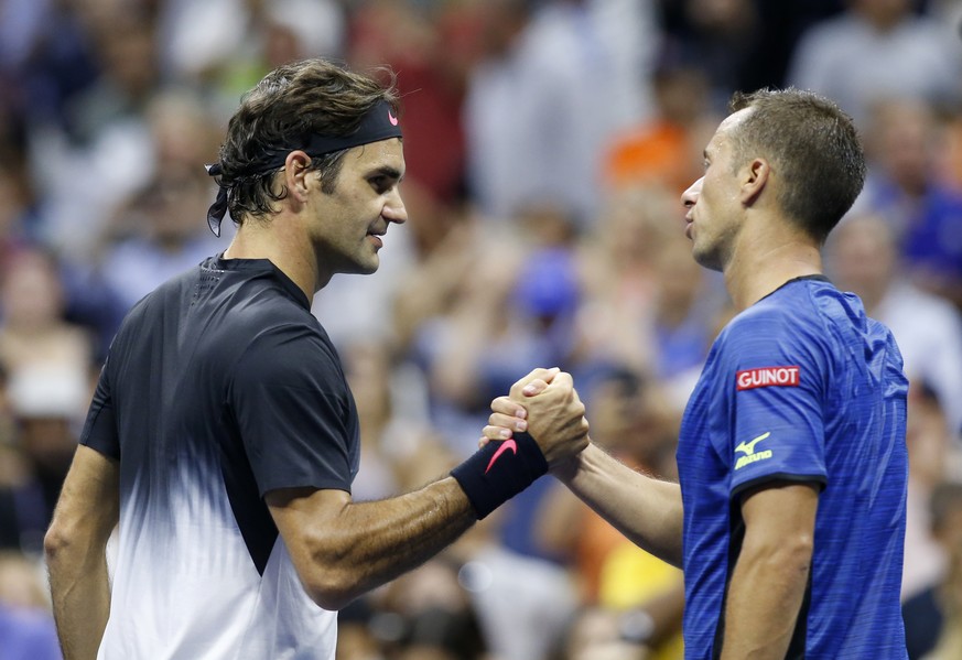 Roger Federer, left, of Switzerland, greets Philipp Kohlschreiber, of Germany, at the net after defeating Kohlschreiber, 6-4, 6-2, 7-5, in a fourth-round match at the U.S. Open tennis tournament in Ne ...