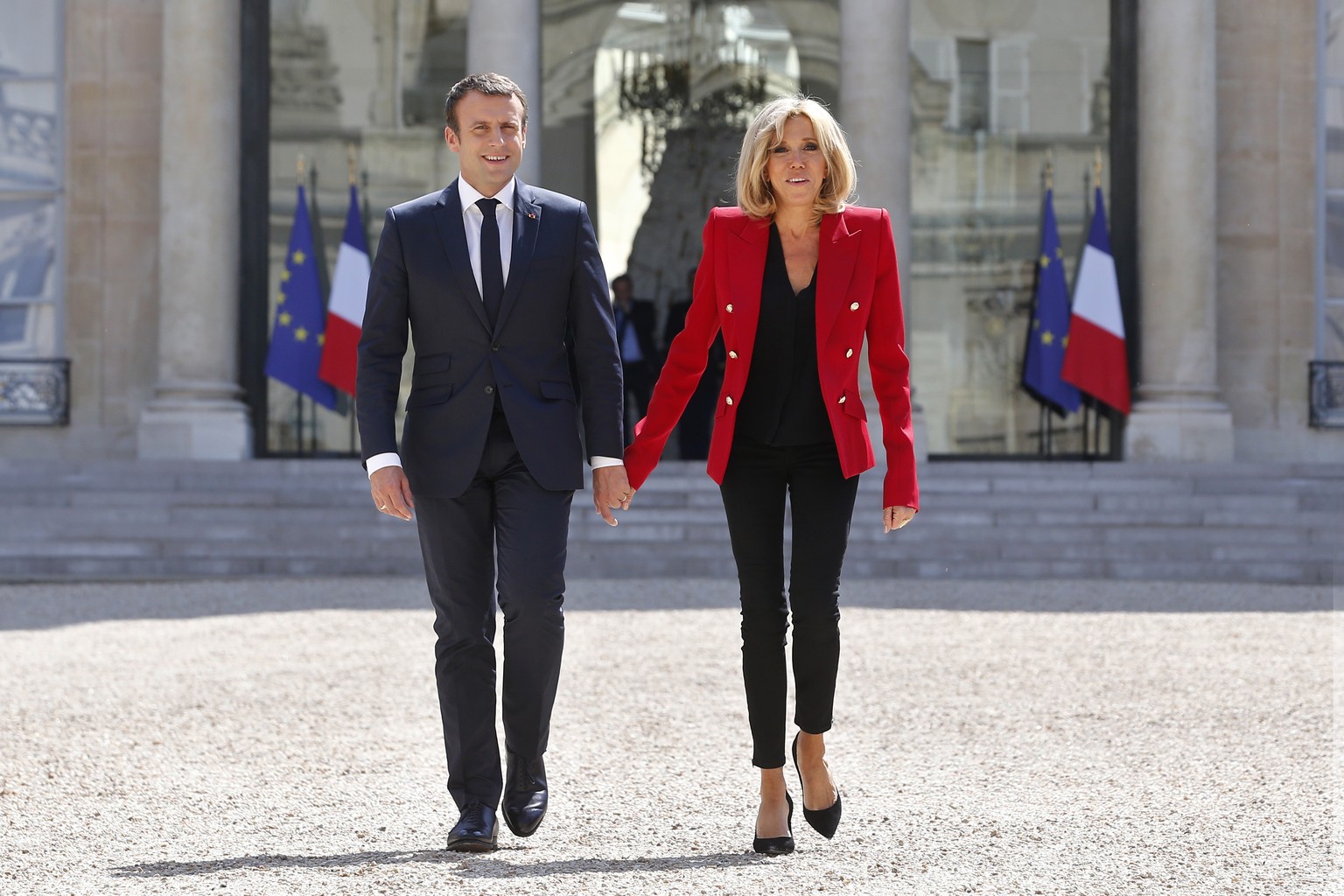 FILE- In this Thursday, July 6, 2017 file photo, France&#039;s President Emmanuel Macron and his wife Brigitte, walk toward the Elysee Palace courtyard, to welcome autistic people, prior to the launch ...