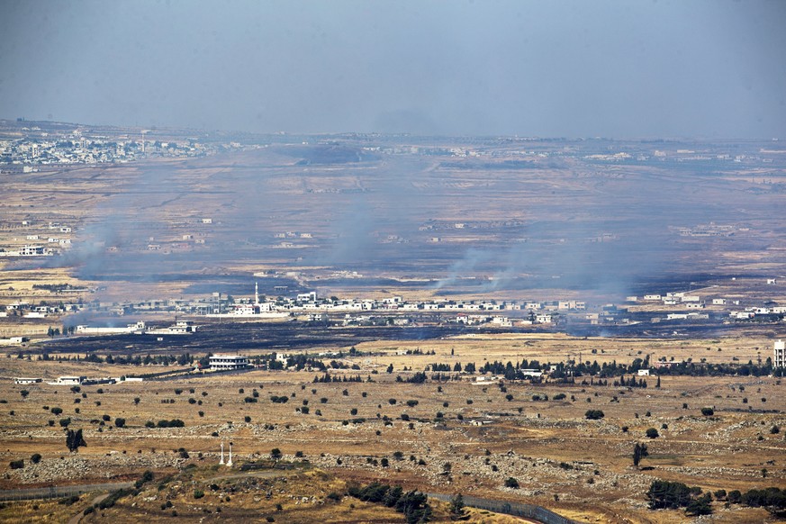 epa06047919 Smoke rise from Syrian village as a result of fighting near the city of Quneitra, in the Golan Heights, 24 June 2017. An Israeli army spokesman reported that in response to over ten projec ...