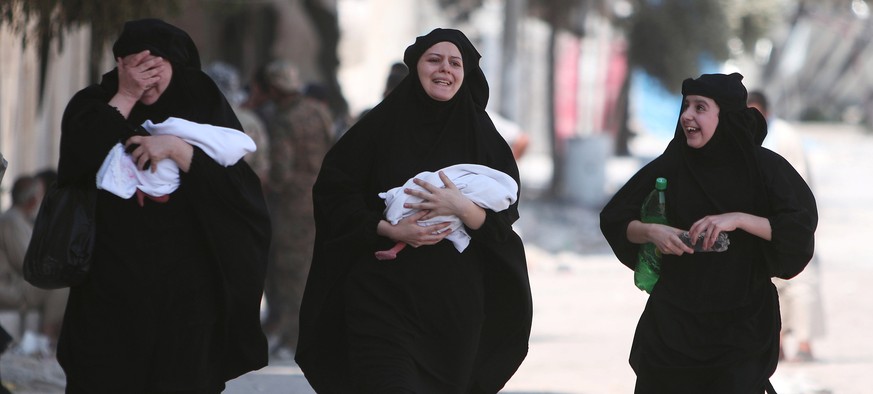 Women carry newborn babies while reacting after they were evacuated by the Syria Democratic Forces (SDF) fighters from an Islamic State-controlled neighbourhood of Manbij, in Aleppo Governorate, Syria ...