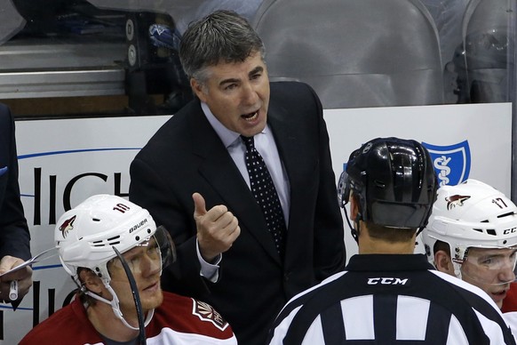 Phoenix Coyotes coach Dave Tippett, center, talks with referee Stephane Auger in the third period of an NHL hockey game against the Pittsburgh Penguins in Pittsburgh, Tuesday, March 25, 2014. The Coyo ...