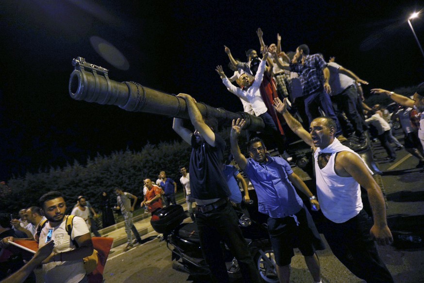 People stand on a Turkish army tank at Ataturk airport in Istanbul, Turkey July 16, 2016. REUTERS/ALDEMIR NO SALES. NO ARCHIVES. TURKEY OUT. NO COMMERCIAL OR EDITORIAL SALES IN TURKEY.