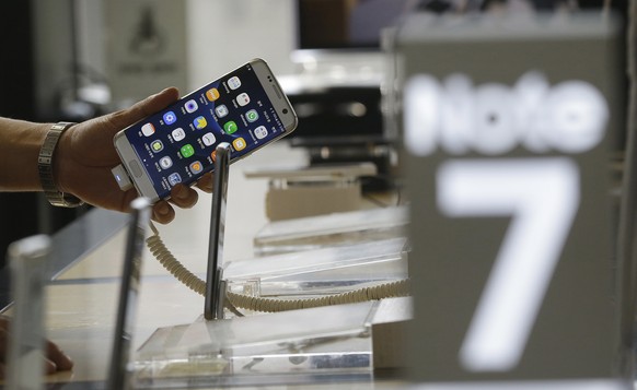 A customer holds a Samsung Electronics Galaxy Note 7 smartphone at the headquarters of South Korean mobile carrier KT in Seoul, South Korea, Friday, Sept. 2, 2016. Samsung will issue a global recall o ...