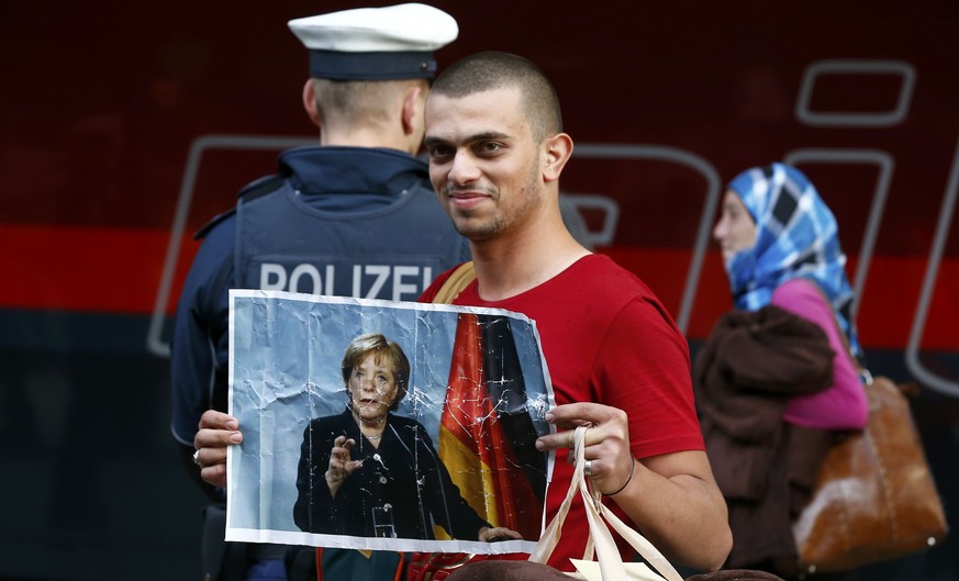 Dankbarkeit für Merkels Politik: Ein Flüchtling hält ein Bild der Deutschen Bundeskanzlerin hoch.